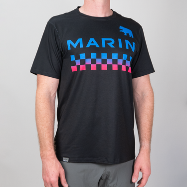Person wearing a black t-shirt with colorful graphics and 'MARIN' branding on a gray background