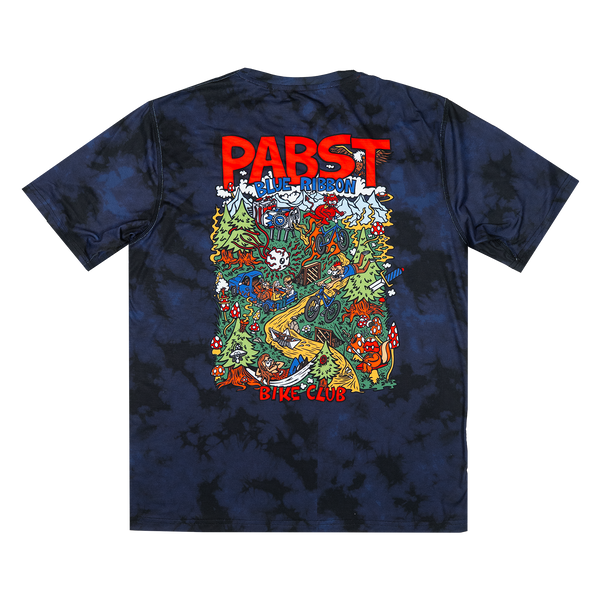 A dark navy blue tie-dye t-shirt with a large, colorful graphic print on the back. The graphic features the text 'PABST' in bold red letters at the top and 'BIKE CLUB' at the bottom, surrounding a detailed multicolor illustration of a psychedelic desert scene with cacti, a yellow dune, and a skull.