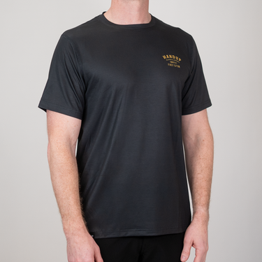 Person wearing a black t-shirt with a logo on a gray background