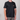 Person wearing a black t-shirt with a small logo on a plain background