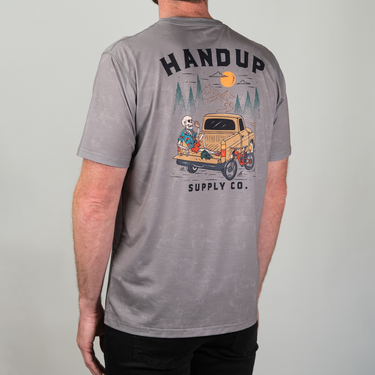 Gray t-shirt with 'Handup Supply Co.' graphic on the back, featuring a vintage truck and skeleton character.