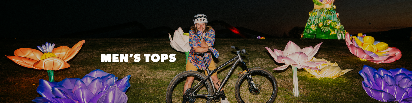 Person on a bike with colorful flower-shaped lanterns at night, featuring 'Men's Tops' text.
