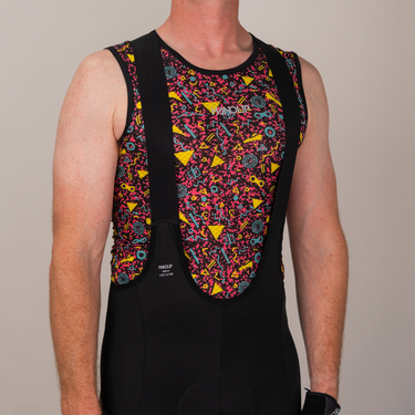 Person wearing a colorful patterned sleeveless shirt with a neutral background