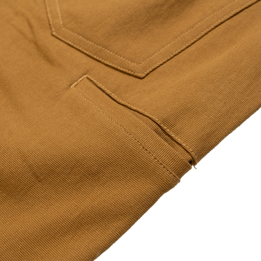 Close-up of a brown fabric with a pocket detail on a white background