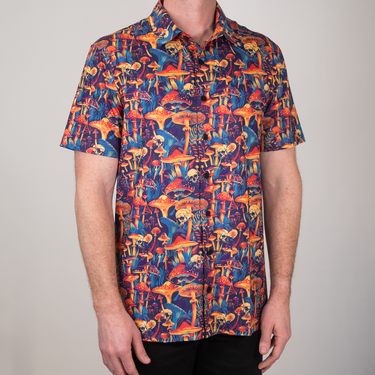Person wearing a colorful mushroom pattern shirt against a plain background