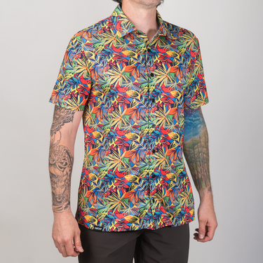 Person wearing a colorful floral patterned shirt on a plain background