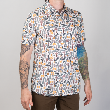 Person wearing a patterned shirt with a neutral background