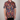 Person wearing a colorful patterned shirt with a plain background