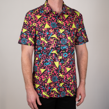 Person wearing a colorful patterned shirt with a plain background