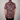 Person wearing a colorful patterned shirt with a plain background