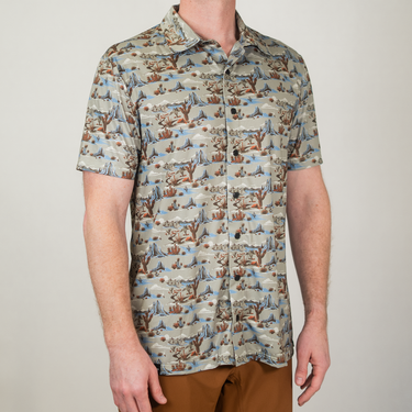 Person wearing a patterned shirt with a neutral background