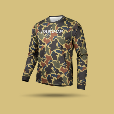 Camouflage-patterned long-sleeve shirt with 'HANDUP' branding on a beige background