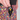 Close-up of a person wearing multicolor patterned shorts with a black zip pocket and a hand inserting a black key fob with a gold buckle. The brand name HANDUP is visible on the waistband and inside the pocket.