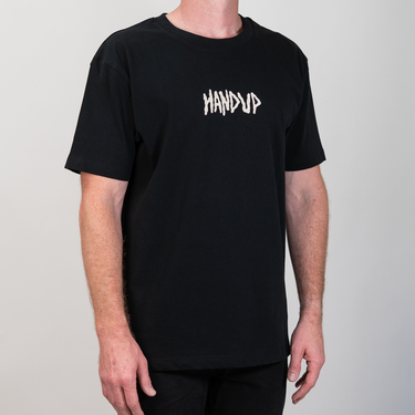 A man wearing a black short-sleeve t-shirt with the word 'HANDUP' printed in white across the chest, photographed against a plain light gray background.