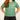 Person wearing a green t-shirt with a logo on a plain background