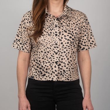 Person wearing a leopard print shirt against a gray background