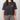 Person wearing a black t-shirt with a logo on a plain background