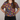 Person wearing a colorful patterned shirt with hands on hips against a gray background