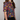 Person wearing a colorful patterned shirt with a plain background