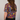 Person wearing a colorful patterned shirt with a plain background