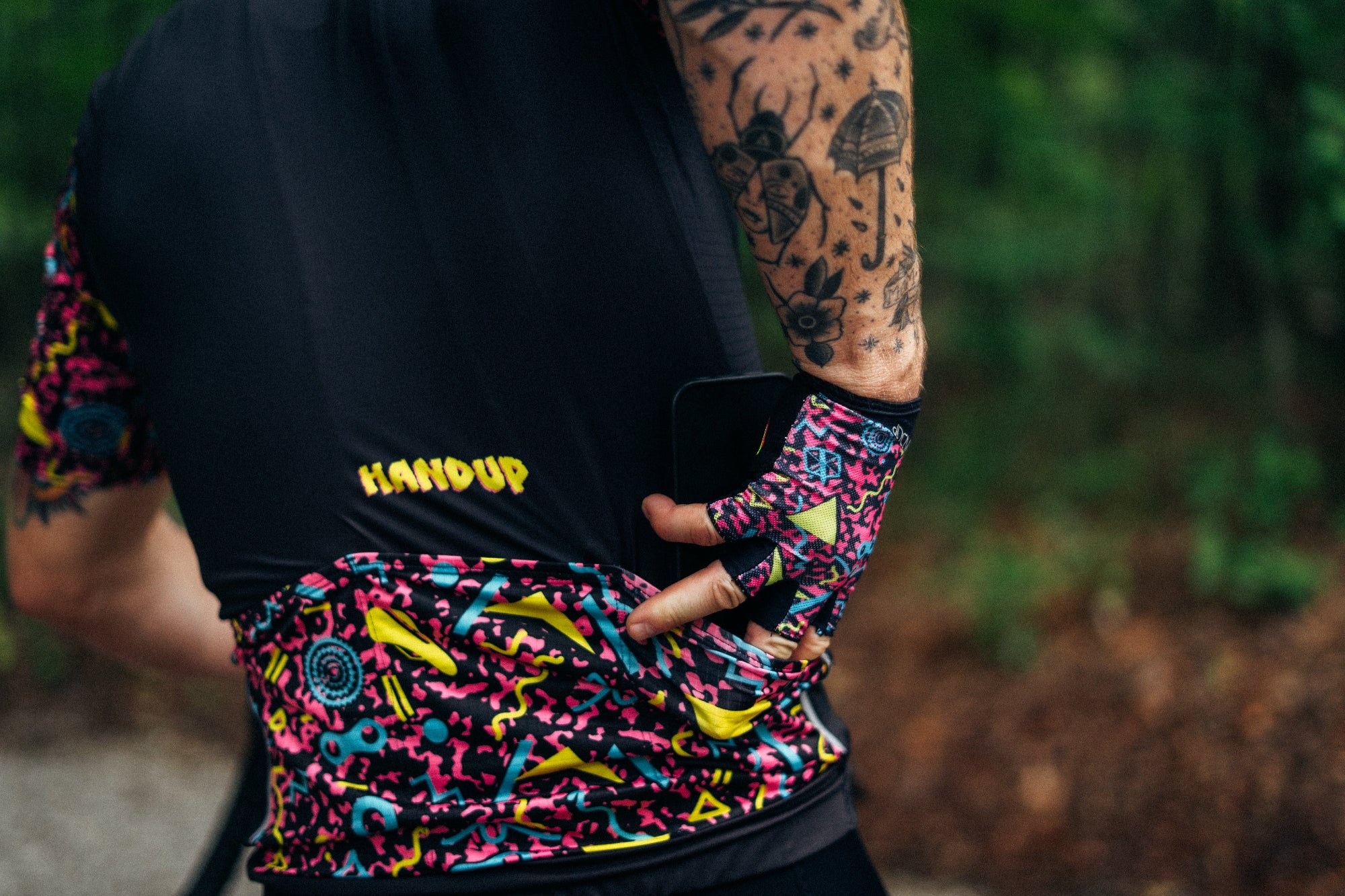 Person wearing a colorful cycling outfit with 'Handup' branding.
