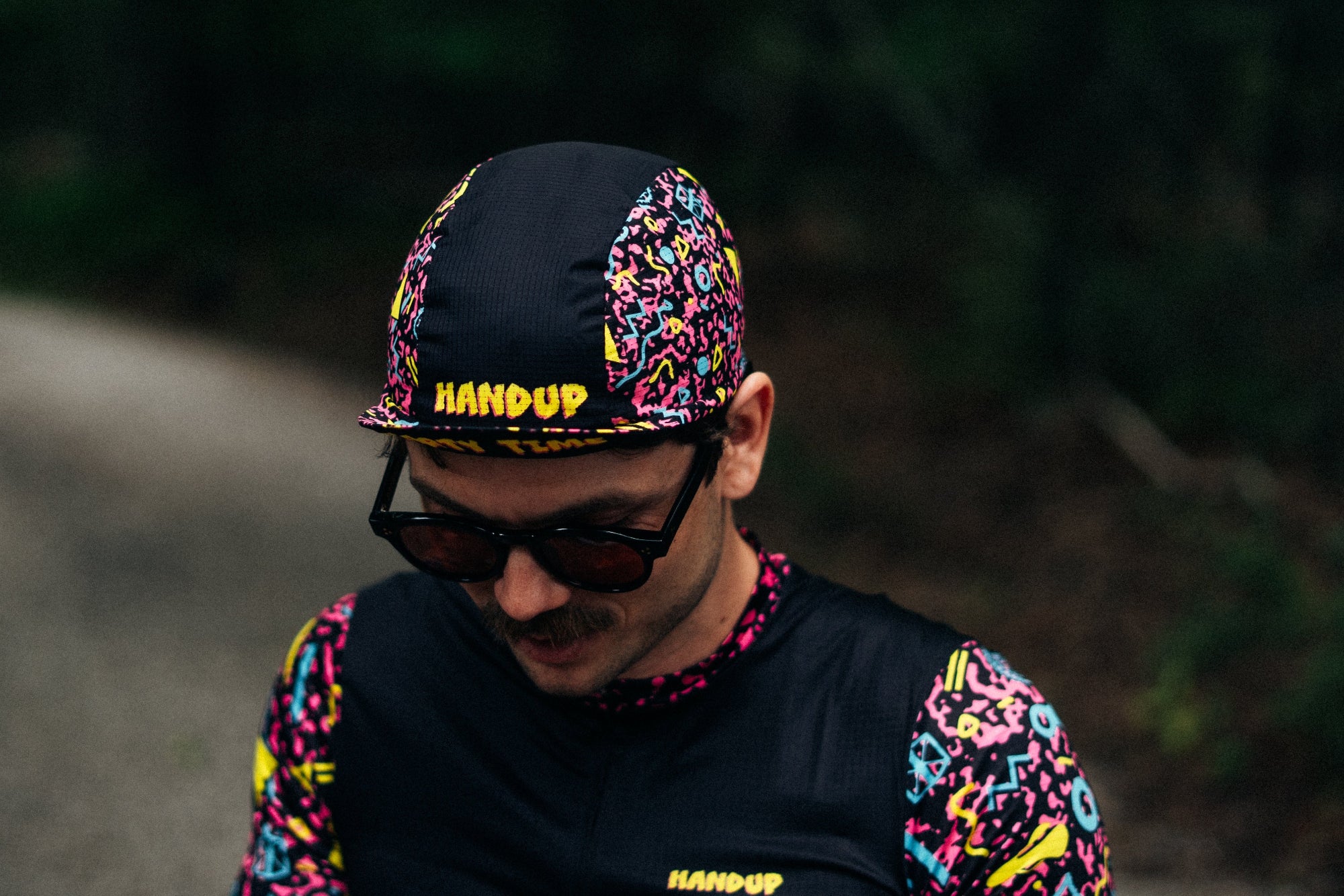 Person wearing a colorful outfit with 'Handup' branding on a road.