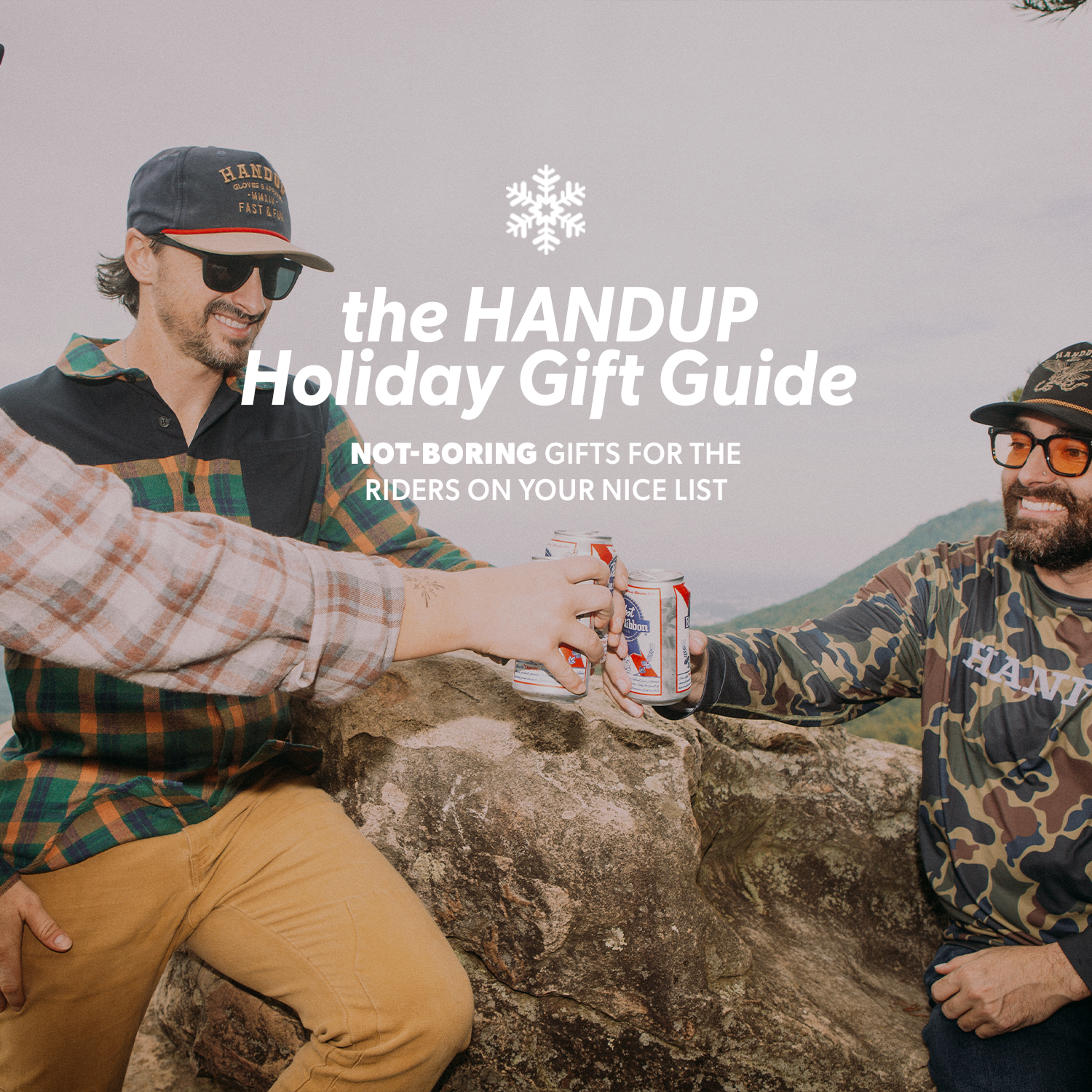 Two men sitting on a rock outdoors, with text overlay about the HANDUP Holiday Gift Guide.