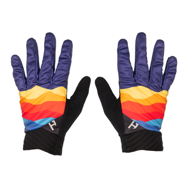 A pair of gloves laid flat on a white background, featuring dark purple backs with horizontal stripes in yellow, orange, red, and blue, black palms, and black ribbed cuffs with a small white logo.
