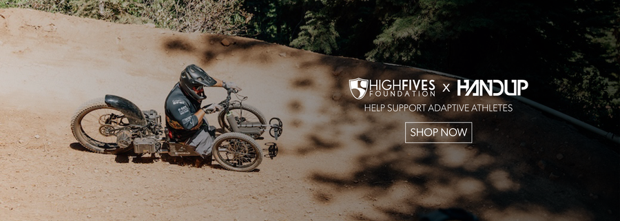 Person riding a motorcycle on a dirt road with 'HighFives' and 'Handup' branding.