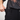 Person wearing black pants with a plain background