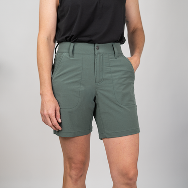  person wearing green shorts and a black shirt with a plain background
