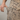 Person wearing a beige outfit with black leopard print pattern, focusing on the waist area.