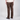 A person shown from the back wearing brown straight-leg jeans, a cream t-shirt, and black Vans sneakers against a light gray studio background.