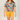 Person wearing a colorful floral shirt and yellow shorts on a plain background