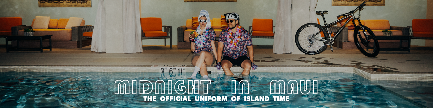 Two people sitting by a pool with a bike in the background, featuring 'Midnight in Maui' text.