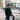 Man with a bicycle wearing a helmet and black jacket in an urban setting