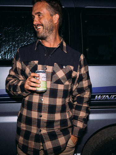 Man holding a can in front of a vehicle with 'Wind Tourer' branding