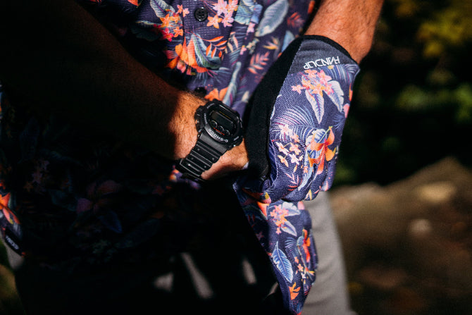 Person wearing a floral shirt and wristband with a watch, outdoors.