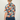 Person wearing a colorful floral shirt with a neutral background