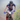 A mountain biker wearing a red, white, and blue HAOLO cycling jersey and matching shorts rides a bike on a dirt trail with green foliage in the background.