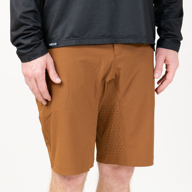 A man with a black long sleeve shirt and brown shorts with a white background
