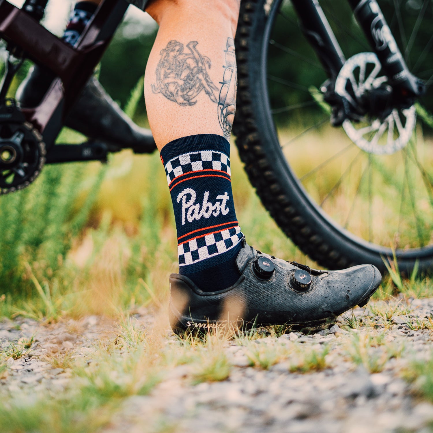 sock inside of a cycling shoe with tattoos and pabst logoing