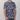 Person wearing a patterned shirt with blue, white, and red design on a plain background