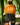 Person on a bike wearing an orange t-shirt with a graphic design in a forest setting