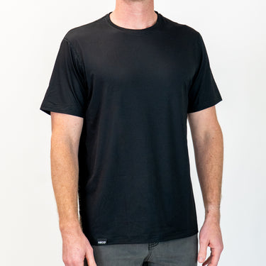 Person wearing a plain black t-shirt on a white background