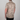 Person wearing a beige shirt with black spotted pattern against a gray background