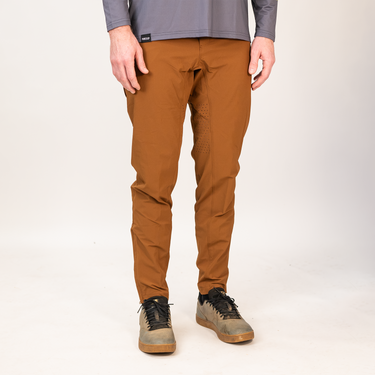 Person wearing brown pants and gray shoes on a white background