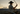 A cowboy wearing a black wide-brim hat and a blue-and-white patterned short-sleeve shirt rides a horse at sunset, holding a lasso. Large text on the left reads 'WESTERN WAYS' with 'SHOP THE COLLECTION' below.