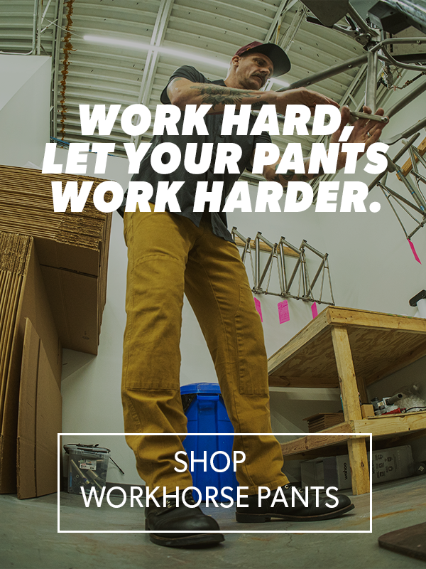 Person wearing yellow work pants in a workshop with text overlay.