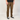 A person wearing brown straight-leg work pants, a black t-shirt, and black Vans sneakers, standing against a light gray studio background.